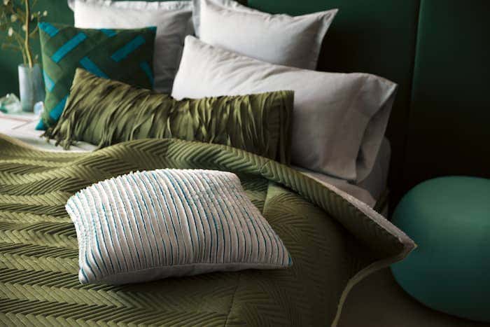 Bed with olive green comforter and green accent pillows