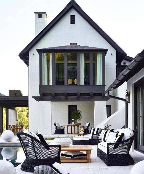 Summer Classics black and white furnishings in an organic form complement the crisp exterior of this home. Photo courtesy of Summer Classics