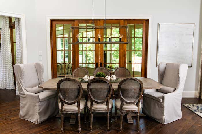 A family dining space features Sunbrella performance fabrics on host and hostess chairs, providing durability, cleanability and comfort.