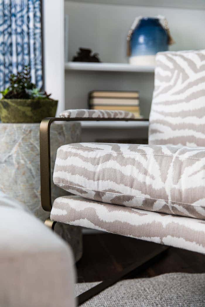 A reading nook is carved out of the master bedroom. A vintage brass armchair gets a fresh look with Zebra Flax Sunbrella performance fabric.