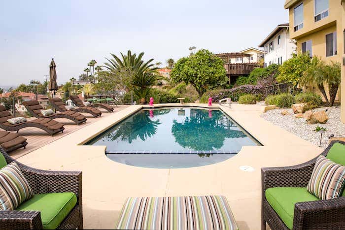 Poolside seating displays bold and colorful stripes in Sunbrella Confetti Green