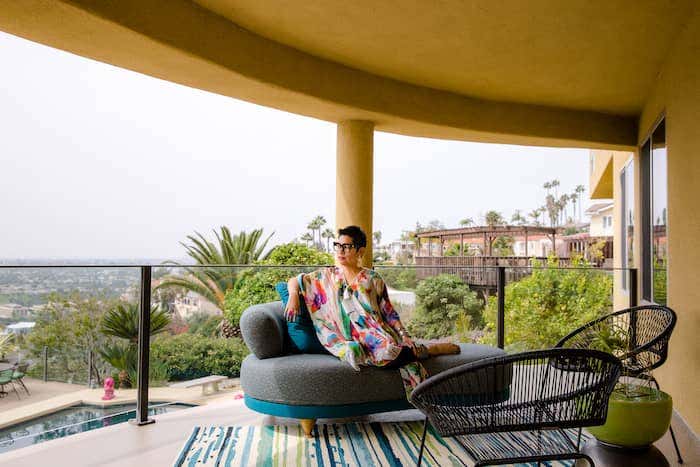 Rachel Moriarty overlooks the scenic pool deck from a geometric chair upholstered in Sunbrella performance fabric