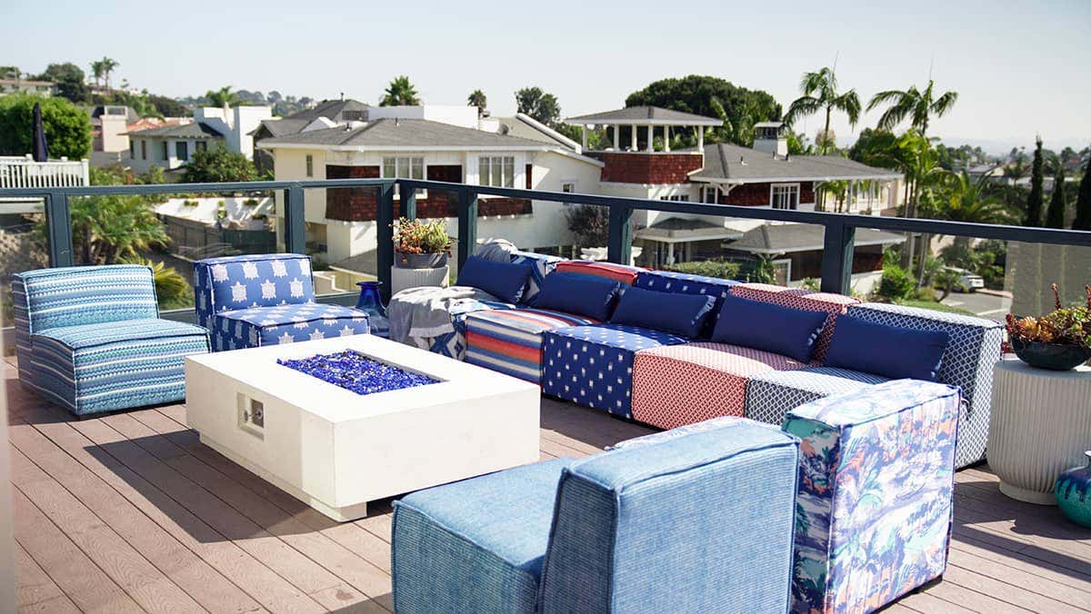 Modular seating around the rooftop fire pit features Sunbrella upholstery in bold and festive patterns