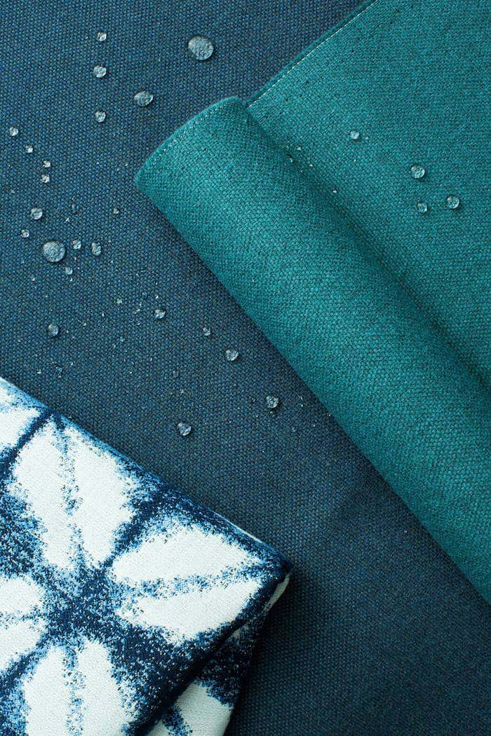 Detail shot of Sunbrella fabrics in shades of blue with water droplets to show water resistant capabilities.