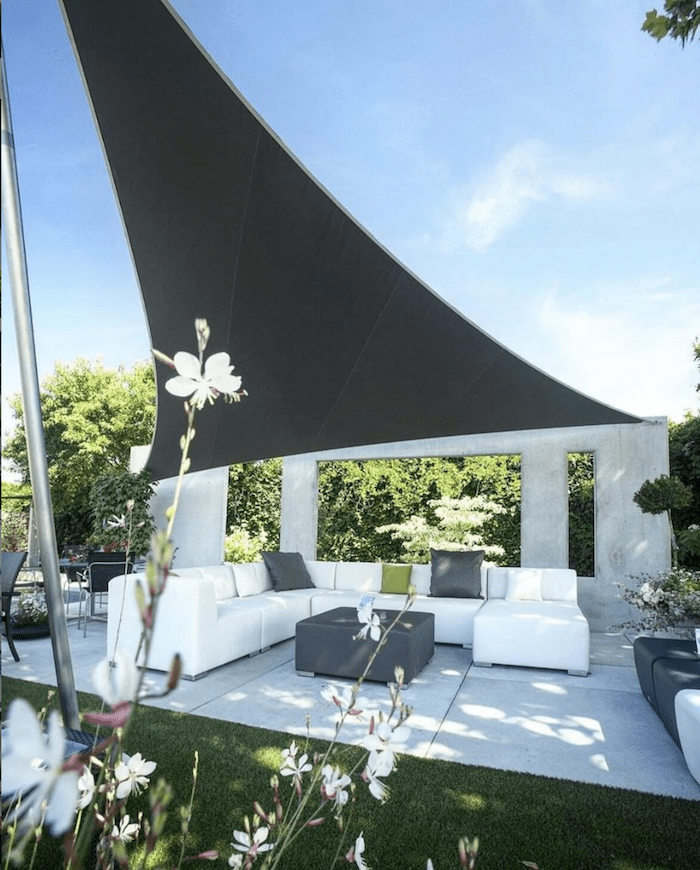 Outdoor living space with a white outdoor sofa and Sunbrella shade sail fabric