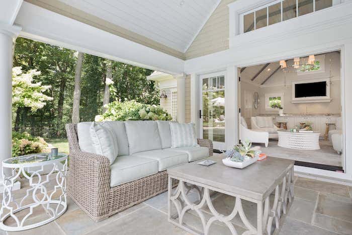 Crisp and light neutral Sunbrella fabrics keep the color scheme consistent throughout the indoor/outdoor living spaces of this stunning Long Island home, styled by Ashbourne designs. Photo credited to Josh Goetz Photography.