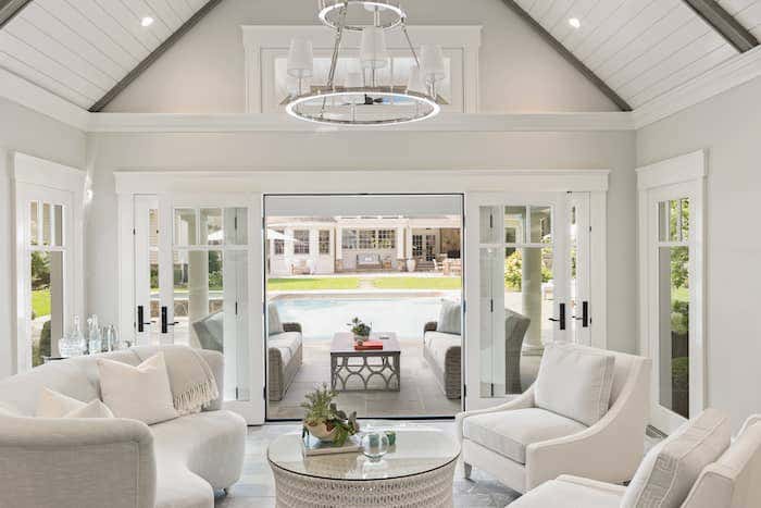 A sliding glass door and large floor to ceiling windows help to eliminate the feeling of separation between your living room and outdoor space, while Sunbrella clad sofas create a seamless transition between areas. Photo credited to Josh Goetz Photography.