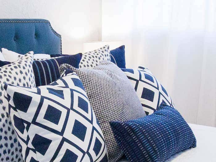 Layered pillows in Haven and Harmony’s Water’s Edge Curation, inspired by a nautical aesthetic. Fabrics incorporate soft creams, bright whites, and richy navy blue.