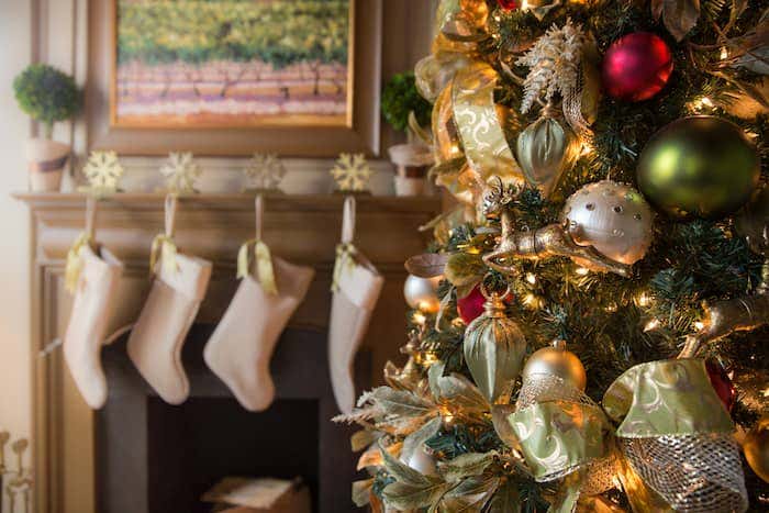 Christmas mantle decorated with gold accents and Sunbrella fabric stockings turning any living room into a space ready to entertain.