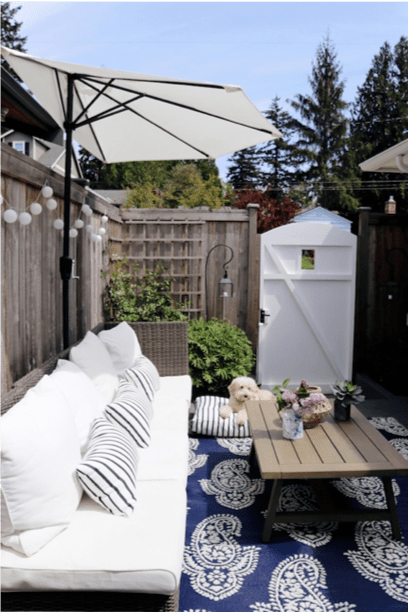 Small backyard patio design with a sofa upholstered in white Sunbrella upholstery fabric