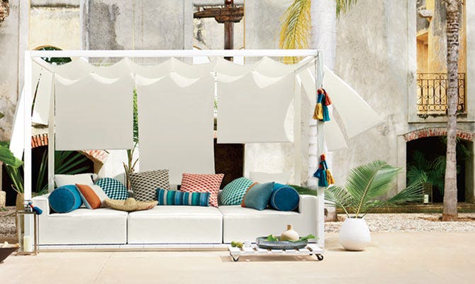 Colorful assorment of cushions displayed on a white couch outdoors