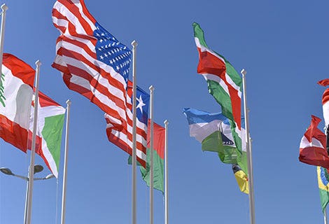 various country flags waving in blue sky