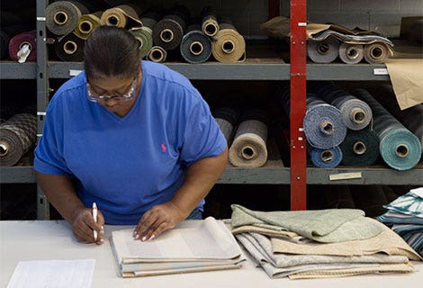 woman checking stack of upholstery samples