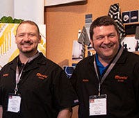 two male sunbrella employees smiling with black uniforms and lanyards