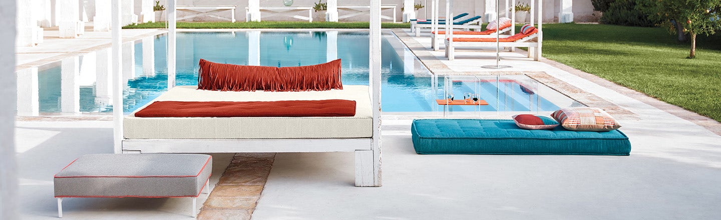 Poolside furniture featuring blue and orange Sunbrella cushion