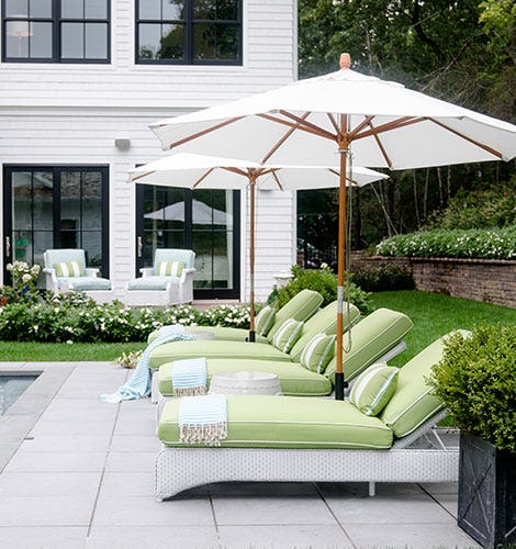 White umbrellas over green pool chairs