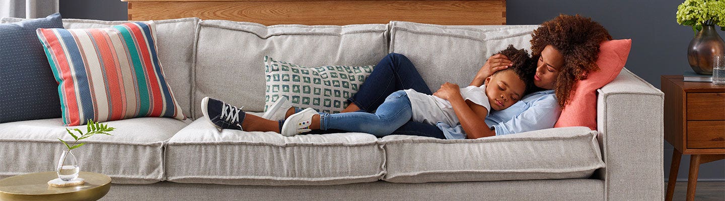 Mother and son laying on grey couch