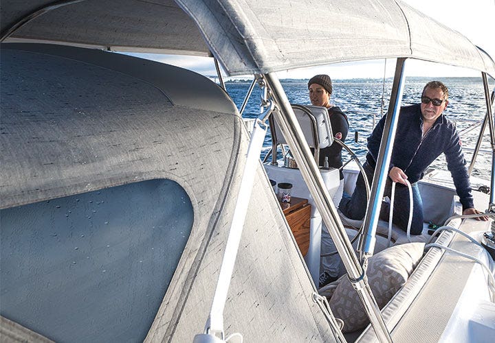 Two men on boat with grey boat cover