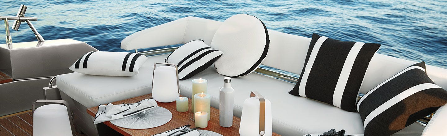 White boat sofa with pillows and candles