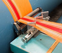 orange and red fabric shown in manufacturing process