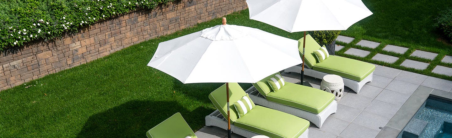 White umbrellas over green pool chairs